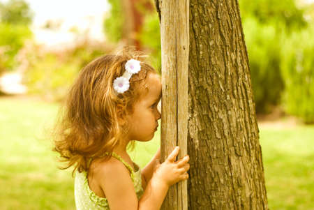 The baby girl plays in park in sun dayの写真素材