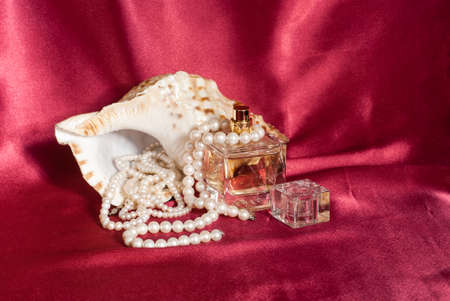 Pearl and perfume on red  backgroundの写真素材