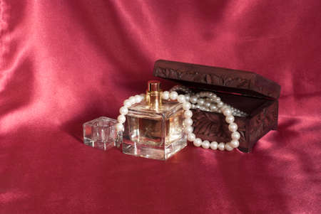 Pearl and perfume on red  backgroundの写真素材