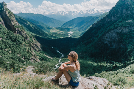 young girl meditates on a background of mountainsの写真素材