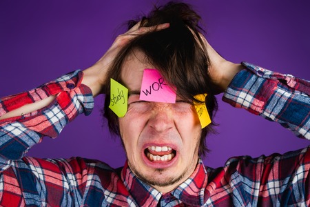 Caucasian man grabs his head and cries, close-up portrait. A man is shocked by his obligations and...
