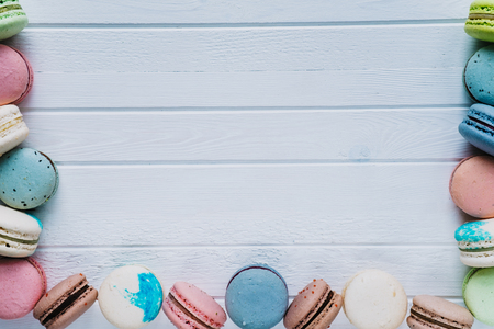 Frame from macaroons or macaron on a white wooden background, almond cookies in the form of decoration, copy space.の写真素材