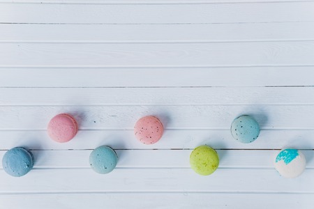 Macaroons or macaron on a white wooden background, almond cookies on a desk, copy space.の写真素材