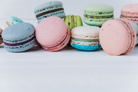 Many delicious macaroons or macaron on a white wooden background close-up, copy spaceの写真素材