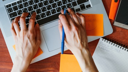 Businesswoman typing on computer, office items on the table
