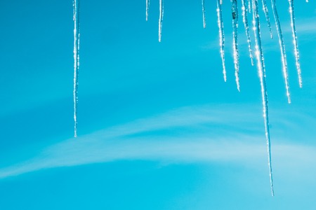 Icicles Shine in the sun against the blue skyの写真素材