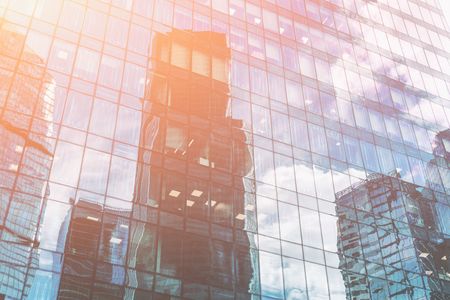 Clouds and skyscrapers are reflected in the windows of the glass, toningの写真素材