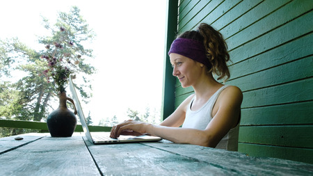 Young business woman tourist freelancer typing on a laptop in the summer outdoors at the recreation centerの写真素材