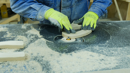 Worker removes chamfer radius cutter in a furniture factory. Manufacture of wooden furniture