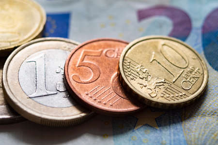 Euro coins on the background of paper bills, close upの写真素材