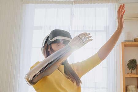 Happy woman with bionic arm and virtual reality gogglesの写真素材