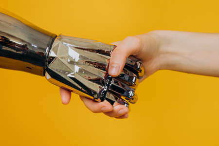 Injured person with bionic prosthesis joins hands with womanの写真素材