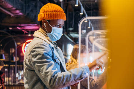 Black man with mask at self-service food ordering kioskの写真素材