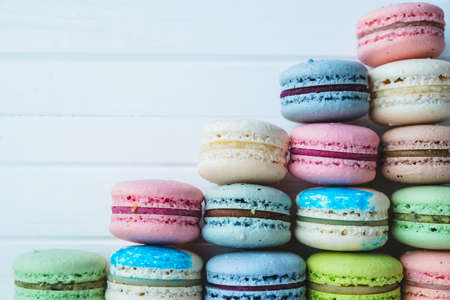Pyramid of macaroons on a white wooden background, multicolored almond cookies. Copy space.の写真素材