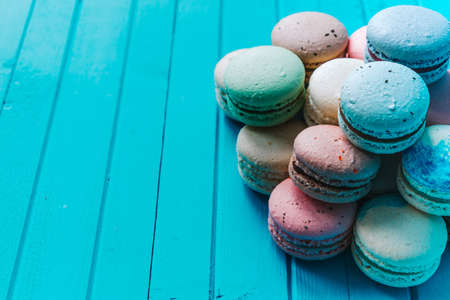 Bunch of macaroons on a turquoise wooden background. Copy spaceの写真素材