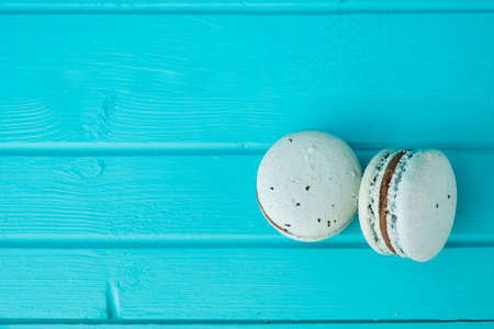 Blue macaroons on a turquoise wooden background, almond cookies in pastel tones, top view, copy spaceの写真素材