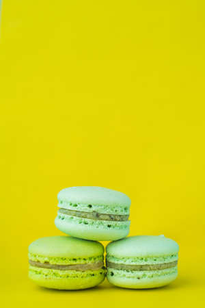 Yellow and white macaroons on a yellow background close up vertically, copy spaceの写真素材