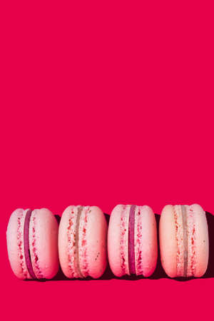Light pink macaroons on a pink background close up vertically, copy spaceの写真素材