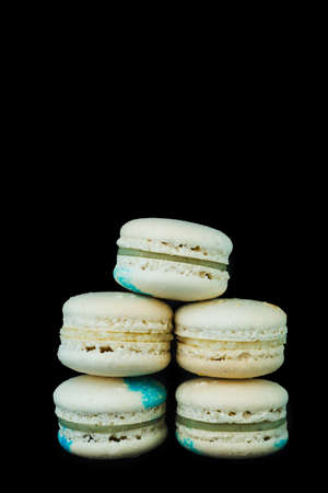 Stack of white macaroons on a black background close up vertically, copy spaceの写真素材