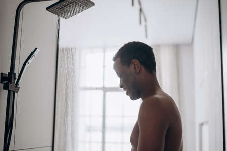 Relaxed African-American man takes shower in bathroomの写真素材