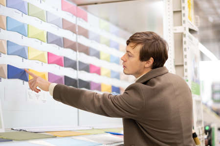 business man chooses paint tile color on color palette