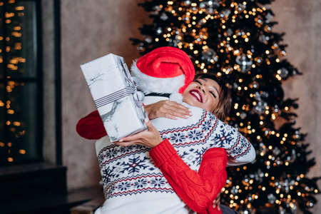 Young couple hugs after exchanging Christmas presentsの写真素材