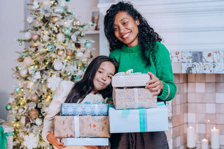 Mother and daughter hold Christmas presents huggingの写真素材