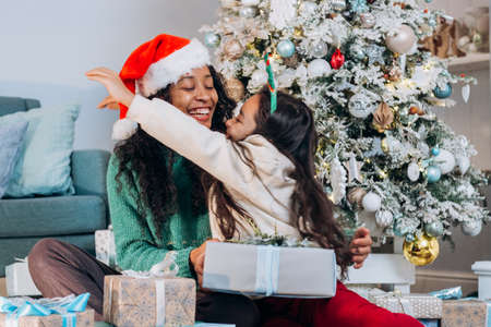 Daughter and African American mother hug on Christmasの写真素材