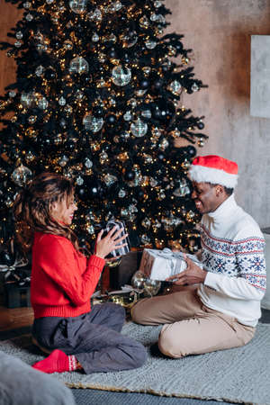Young couple presents Christmas gift boxes to each otherの写真素材