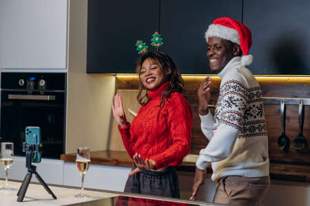 Black man and woman dance in Christmas mood filming videoの写真素材