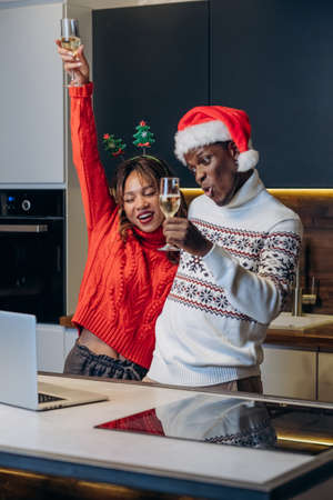 Woman and black man talk via videocall celebrating Christmasの写真素材