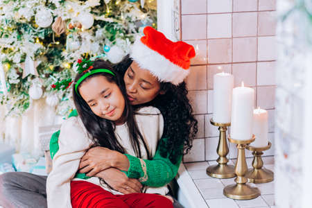 Daughter and mother pose with Christmas decorationsの写真素材