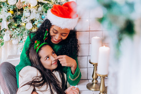 Daughter and mother pose with Christmas decorationsの写真素材