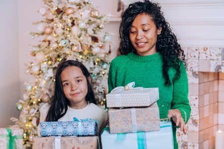 Mother and daughter hold Christmas presents huggingの写真素材