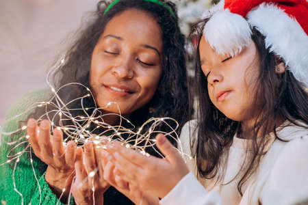 Black mother and daughter pose wrapped with garlandの写真素材