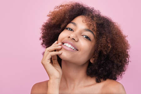 Brunette-haired woman poses against bright pink wallの写真素材