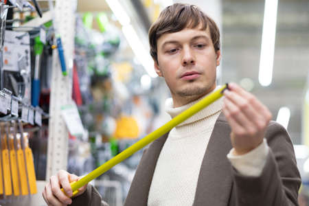 Brunet short-haired man chooses renovation equipmentの写真素材