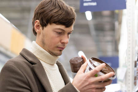 Short-haired man chooses paint for apartment renovationの写真素材