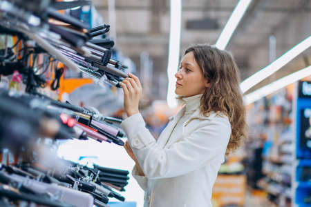 Young brunette woman looks for flat renovation equipmentの写真素材