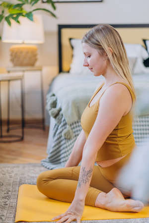 Young blonde woman does yoga meditation and stretchingの写真素材