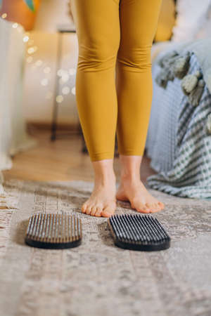 Young woman stands near sport equipment in bedroomの写真素材