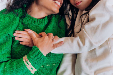 Mother and daughter lie and laugh on Christmas pillowsの写真素材