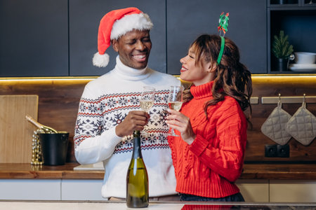 Young woman and black man celebrate Christmas in kitchenの写真素材