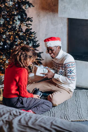 African American man presents girlfriend Christmas giftの写真素材