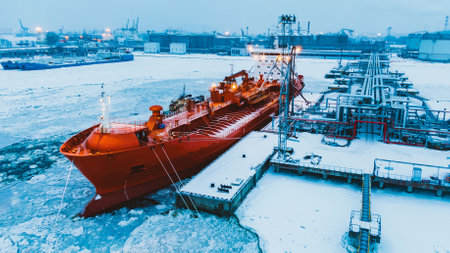 Oil terminal and tanker moored on water covered with iceの写真素材