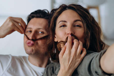 Smiling newlyweds play with hair and smile for selfiesの写真素材