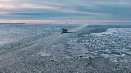 Cargo ship with containers sails through ice hummocksの写真素材