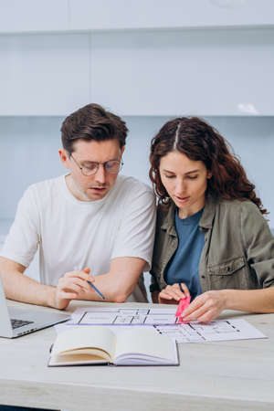 Couple talks about drawings of appartment renovation