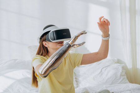 Joyful woman with bionic prosthesis and goggles plays gameの写真素材