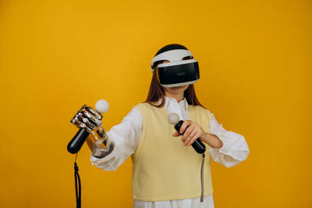 Lady with bionic arm virtual reality goggles and joysticksの写真素材